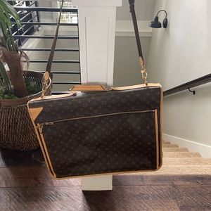 Louie Vuitton garment bag. 2 Louie Vuitton hangers included with brown strap.
